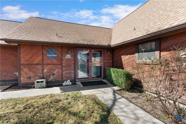 property entrance with a shingled roof