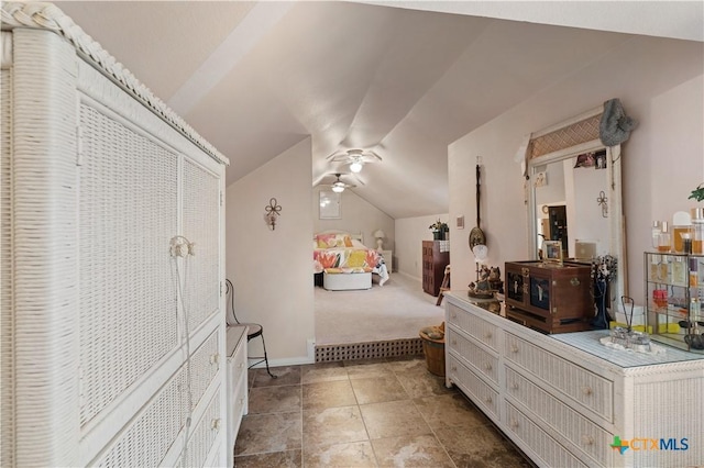 bedroom with lofted ceiling and baseboards