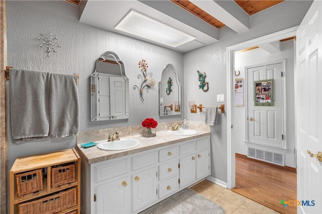 full bathroom featuring double vanity, tile patterned flooring, a sink, and visible vents