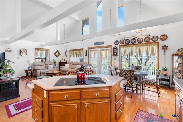 kitchen featuring black electric stovetop, open floor plan, light countertops, and a center island