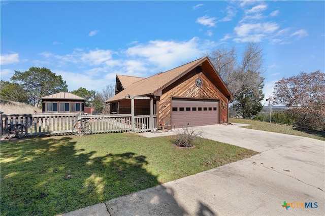 view of front of home with a front lawn, driveway, an attached garage, and fence