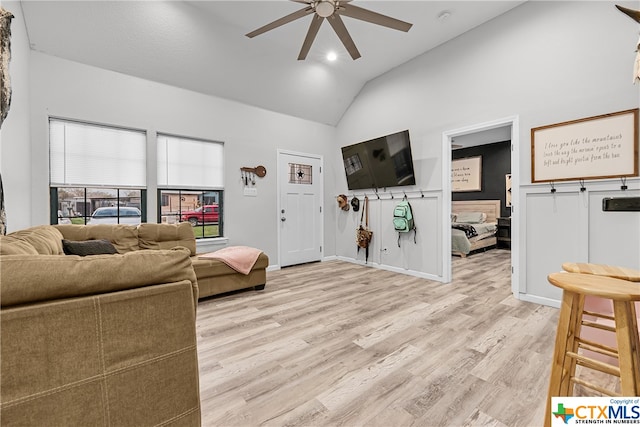 living room featuring ceiling fan, light hardwood / wood-style flooring, and high vaulted ceiling