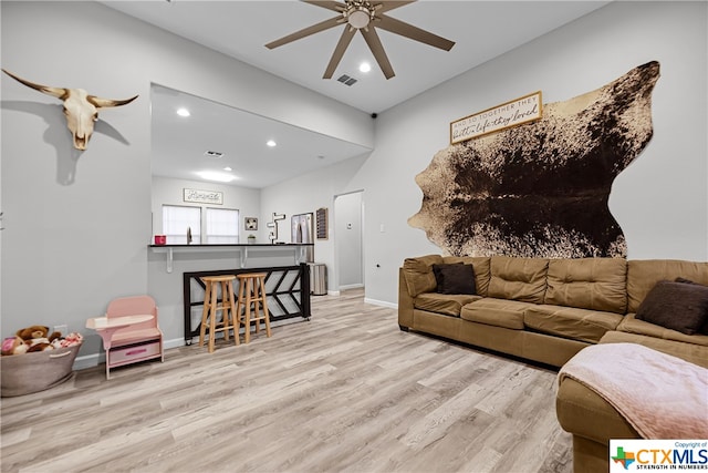 living room with light hardwood / wood-style floors and ceiling fan