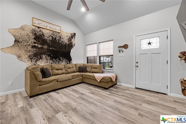 living room featuring light hardwood / wood-style floors, ceiling fan, and vaulted ceiling