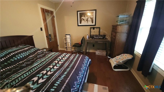 bedroom with hardwood / wood-style flooring and multiple windows