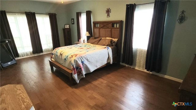 bedroom featuring dark hardwood / wood-style flooring and multiple windows