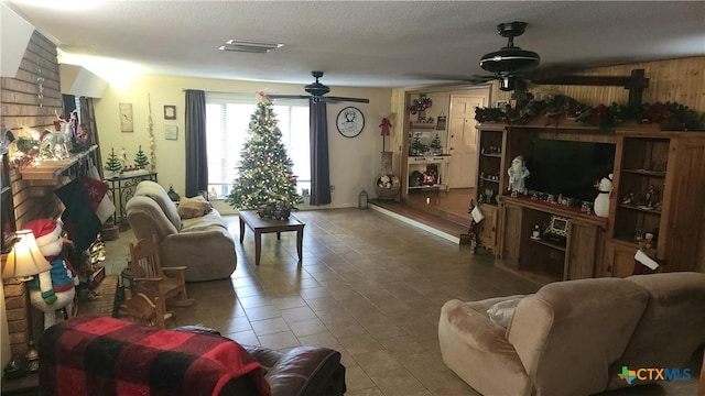 living room featuring tile patterned floors, ceiling fan, and a textured ceiling