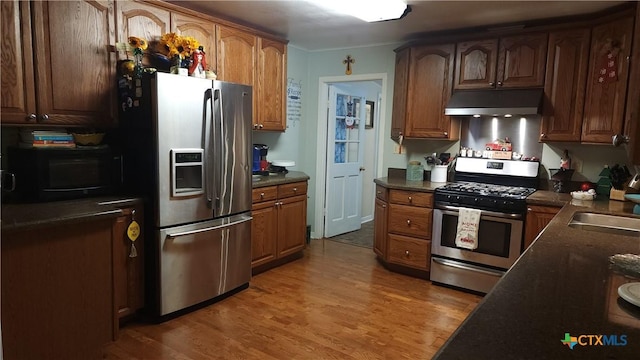 kitchen featuring hardwood / wood-style floors, stainless steel appliances, and sink