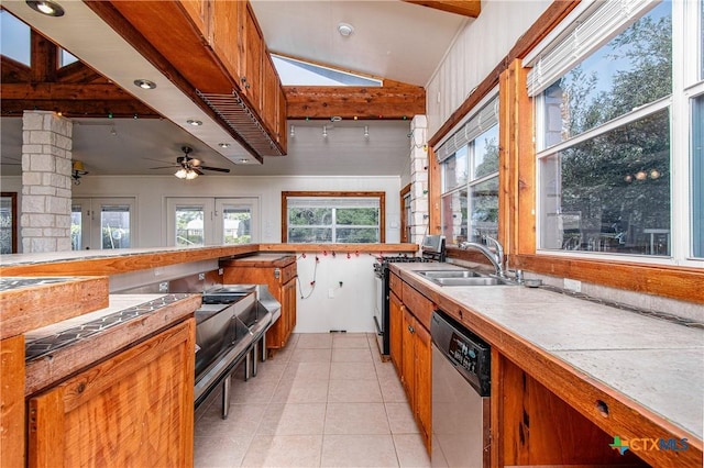 kitchen featuring stainless steel appliances, lofted ceiling, sink, and light tile patterned floors