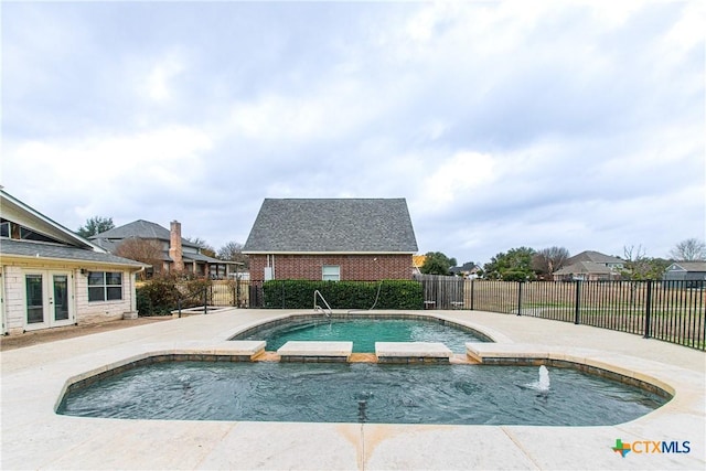 view of pool featuring an in ground hot tub, pool water feature, a patio area, and french doors