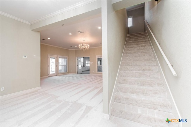 stairs with ornamental molding, a chandelier, and carpet