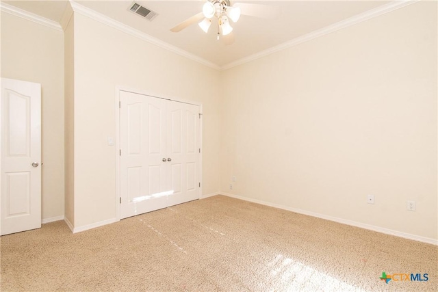 unfurnished bedroom with ceiling fan, ornamental molding, carpet flooring, and a closet