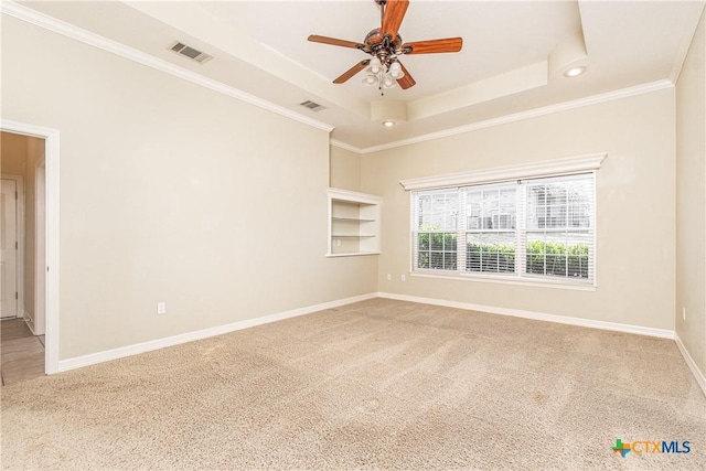 carpeted spare room featuring ornamental molding, a raised ceiling, and ceiling fan