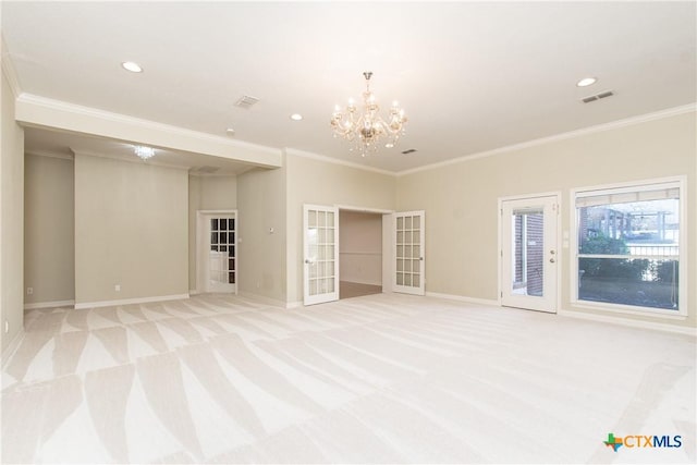 spare room featuring light carpet, ornamental molding, french doors, and an inviting chandelier