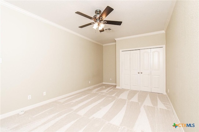 unfurnished bedroom featuring crown molding, a closet, ceiling fan, and light carpet