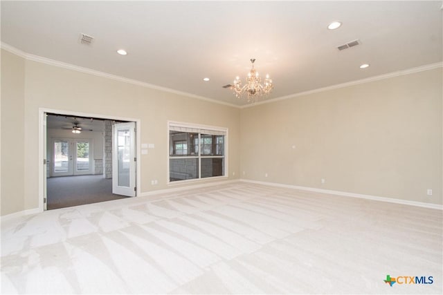 carpeted empty room with an inviting chandelier, crown molding, and french doors