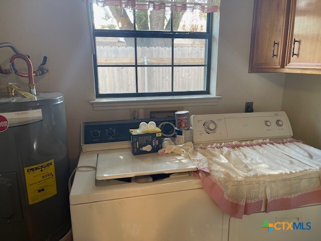 washroom with separate washer and dryer, water heater, and cabinets