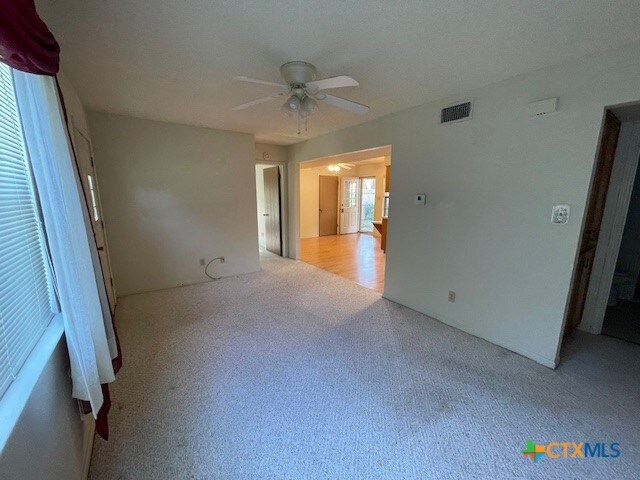 interior space with ceiling fan