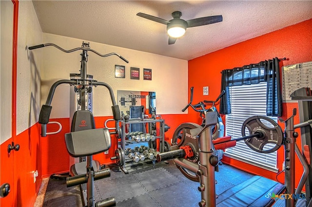 workout area featuring a textured ceiling, ceiling fan, and a textured wall