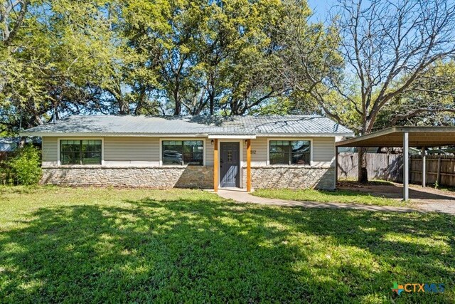 512 W Pecan Dr, Johnson City, TX 78636 - view of front facade with stone siding and a carport