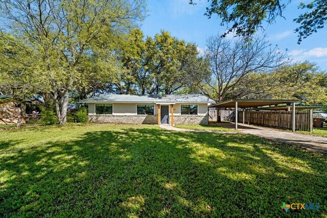 512 W Pecan Dr, Johnson City, TX 78636 - ranch-style house with a detached carport, stone siding, and driveway