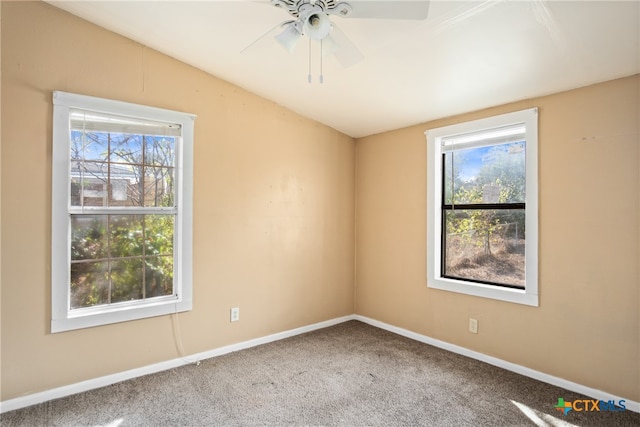 carpeted empty room featuring vaulted ceiling, ceiling fan, and a healthy amount of sunlight