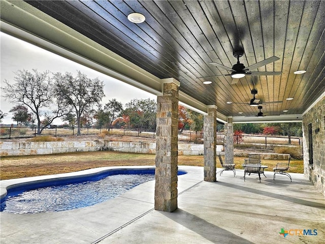 view of swimming pool with ceiling fan and a patio area