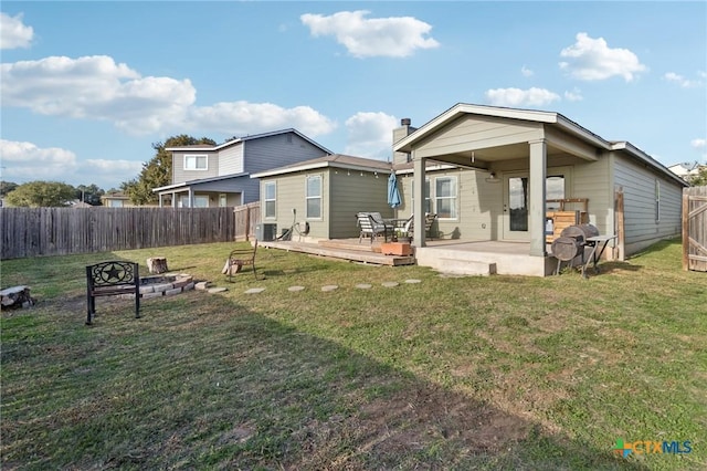 rear view of property featuring central air condition unit, an outdoor fire pit, a yard, a deck, and a patio