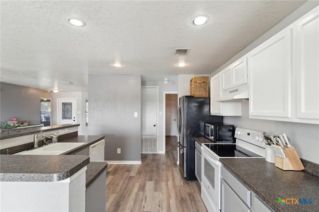 kitchen featuring appliances with stainless steel finishes, sink, white cabinetry, and a textured ceiling