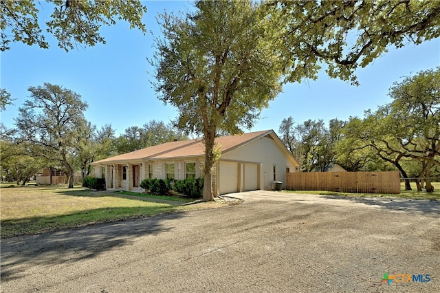 ranch-style house featuring a garage and a front lawn