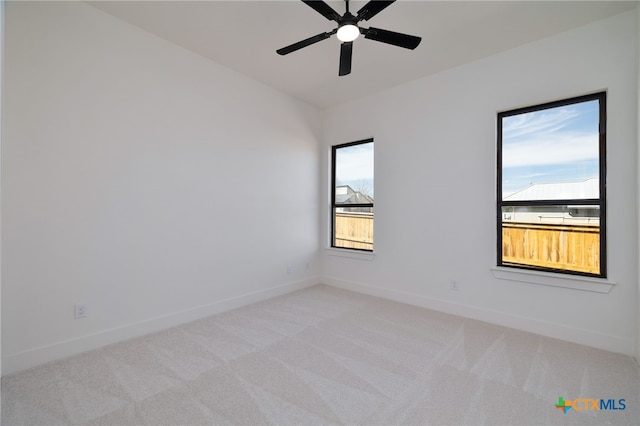 empty room with baseboards, light colored carpet, and ceiling fan