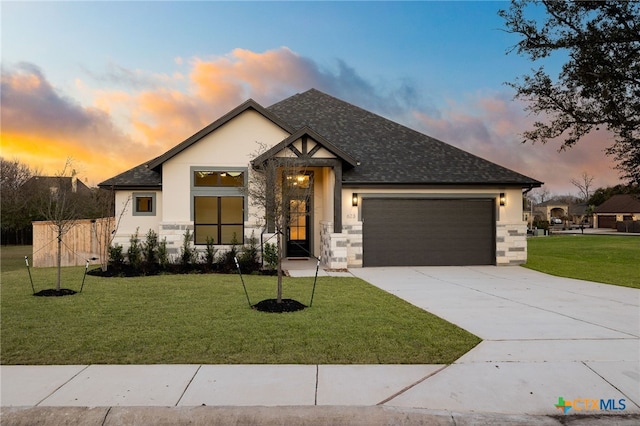 view of front of home with stucco siding, driveway, a lawn, and an attached garage
