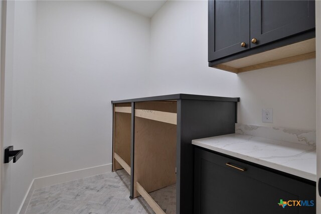 clothes washing area with baseboards