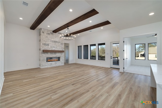 unfurnished living room featuring visible vents, baseboards, beamed ceiling, a stone fireplace, and light wood-style flooring