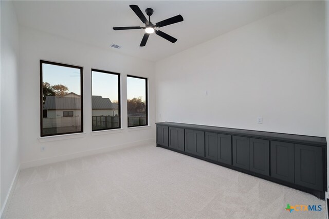 spare room featuring a ceiling fan, visible vents, carpet, and baseboards