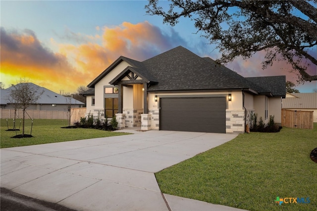 view of front of property with a front yard, an attached garage, stucco siding, concrete driveway, and stone siding