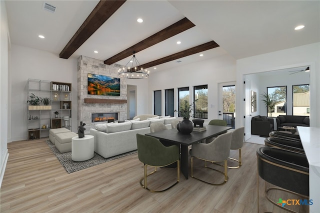 living room featuring visible vents, light wood-style flooring, recessed lighting, a fireplace, and beamed ceiling