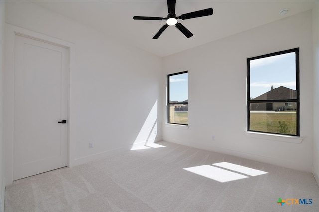 empty room with baseboards, carpet, and a ceiling fan