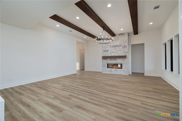 unfurnished living room featuring light wood finished floors, visible vents, a notable chandelier, and baseboards