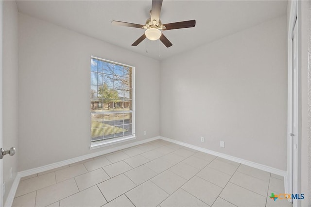 empty room with a ceiling fan, baseboards, and light tile patterned floors