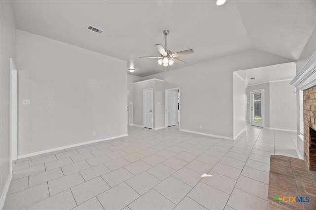 unfurnished living room with ceiling fan, light tile patterned floors, visible vents, vaulted ceiling, and a brick fireplace