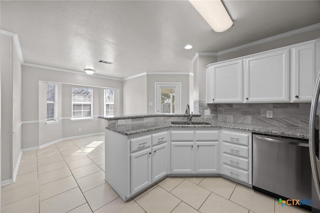 kitchen with a sink, light tile patterned floors, a peninsula, and stainless steel dishwasher