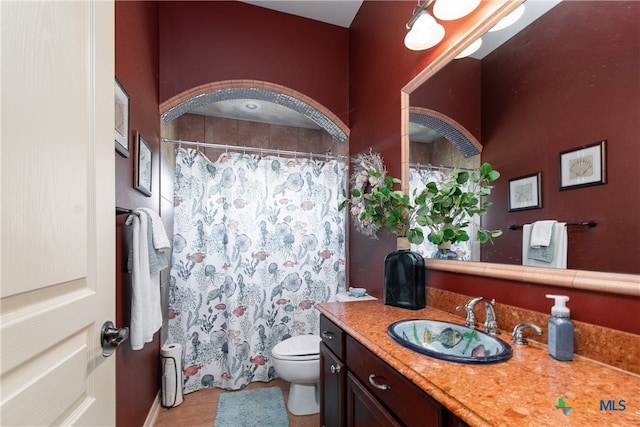 bathroom with toilet, vanity, and tile patterned floors