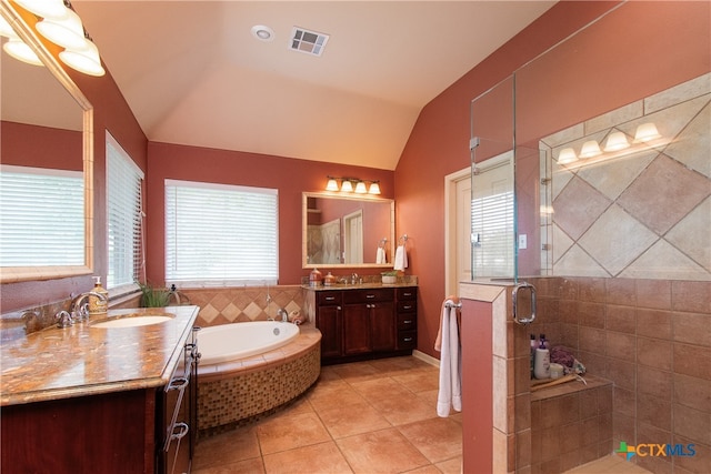 bathroom featuring vanity, independent shower and bath, lofted ceiling, and tile patterned floors