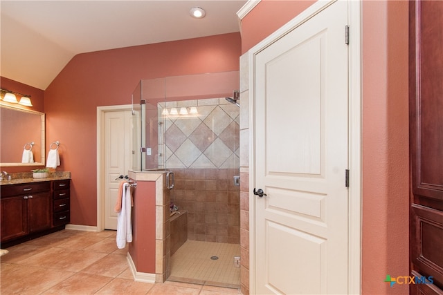 bathroom with tile patterned flooring, lofted ceiling, vanity, and a shower with door