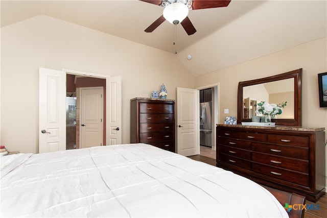 bedroom featuring dark wood-type flooring, stainless steel fridge, lofted ceiling, and ceiling fan