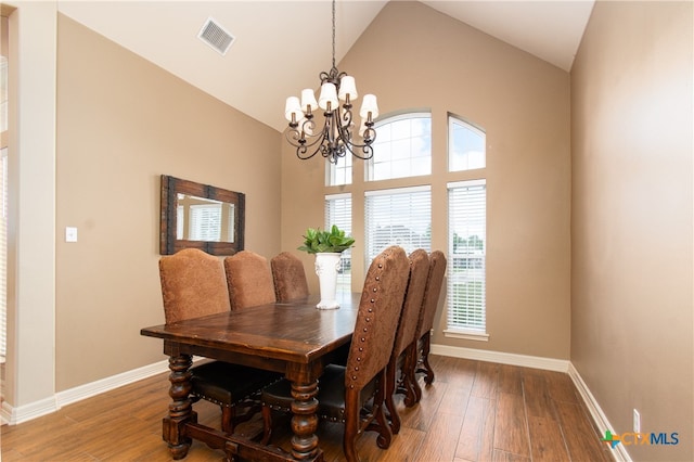 dining room featuring high vaulted ceiling, an inviting chandelier, and hardwood / wood-style flooring