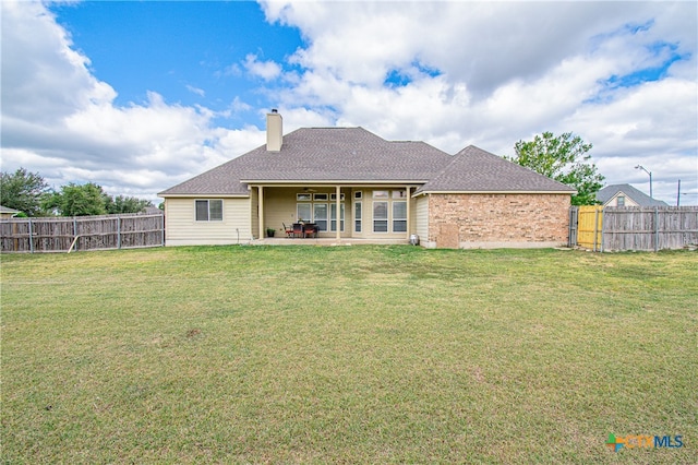 back of property featuring a patio area and a yard