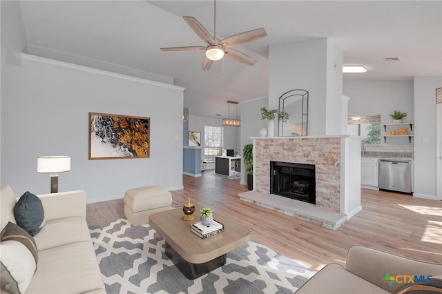 living area featuring visible vents, a fireplace with raised hearth, baseboards, ceiling fan, and light wood-style flooring