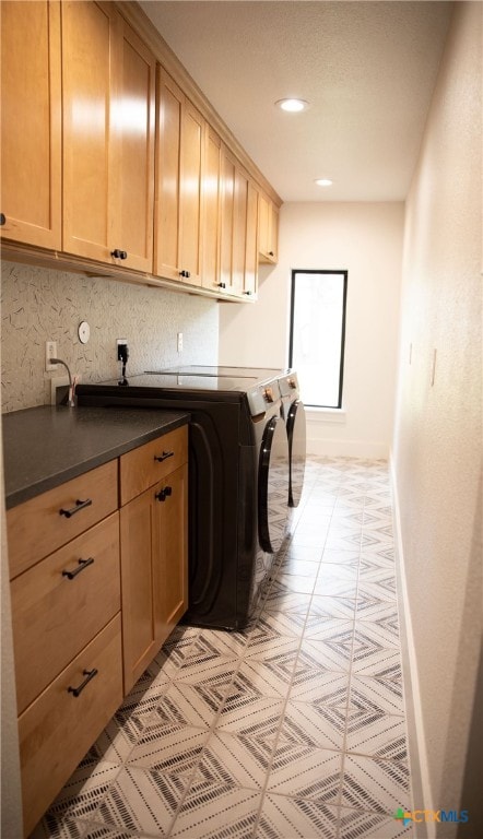 washroom with washing machine and dryer and cabinets